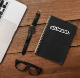 MBMBAM Quote Sticker on Journal in Office with Laptop and Watch