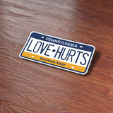 Love Hurts Philly Sports Pennsylvania License Plate Sticker on wood background