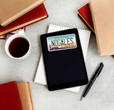 Nogales Arizona License Plate Sticker on Kindle eReader with Books and Coffee Mug