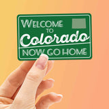 Welcome to Colorado Now Go Home Sticker on Orange Background