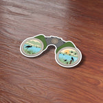 Binoculars Birdwatching Bumper Sticker on Wood Desk in Office