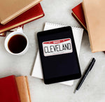 Cleveland Sticker on ereader Tablet with Books and Coffee Mug