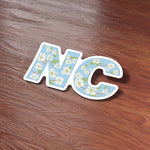 Cute Dogwood NC State Flower North Carolina Bumper Sticker on Wood Desk in Office