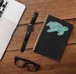 Cute Hawaiian Turtle Ocean Sticker on Journal with Laptop and Watch on Wood Desk in Office