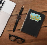 Sunflower Iowa Sticker on Journal with Laptop and Watch on Wood Desk in Office