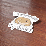 Funny It is Wednesday My Dudes Frog Meme Sticker on Journal with Laptop and Watch on Wood Desk in Office