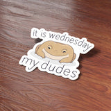 Funny It is Wednesday My Dudes Frog Meme Sticker on Journal with Laptop and Watch on Wood Desk in Office