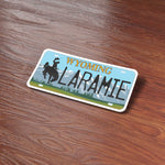 Laramie Wyoming License Plate Sticker on Wood Desk in Office