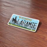 Laramie Wyoming License Plate Sticker on Wood Desk in Office