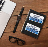 Louisville KY and Bourbon Kentucky Stickers on Journal with Laptop and Watch on Wood Desk in Office