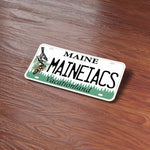 Maineiacs Maine License Plate Stickers on Wood Desk