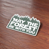 May the Forest Be With You Camping Sticker on Wood Desk in Office
