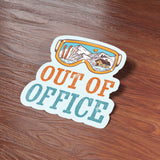 Out of Office Sticker on Wood Desk