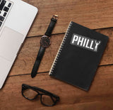 Philly Rocky Sticker on Journal with Macbook and Watch on Wood Desk in Office