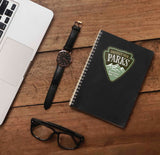 Protect Our Parks Sticker on Journal with Macbook and Watch