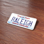 Raleigh North Carolina License Plate Sticker on Wood Desk
