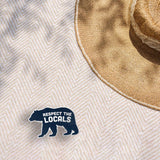 Blue Respect the Locals Bear Bumper Sticker on Beach Blanket Outdoors