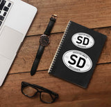 South Dakota White Oval Sticker on Journal with Laptop and Watch