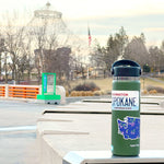 Spokane WA License Plate Sticker and Washington State Huckleberry Sticker on Hydroflask in Riverfront Park