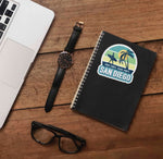 San Diego Beach Sticker on Journal with Laptop and Watch on Wood Desk in Office