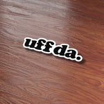 Uff Da Sticker on Wood Desk in Office