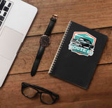 Route 66 Sticker on Journal with Laptop and Watch on Wood Desk in Office