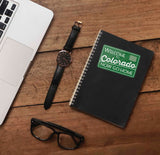 Cute Colorado Sticker on Journal with Watch and Laptop on Wood Desk in Office