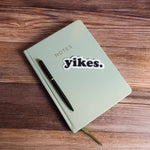 Yikes Funny Sticker on Journal with Pen