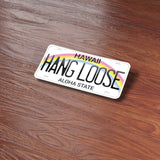Hang Loose Hawaii License Plate Sticker on Wood Desk