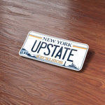 Upstate New York License Plate Sticker  on Wood Desk